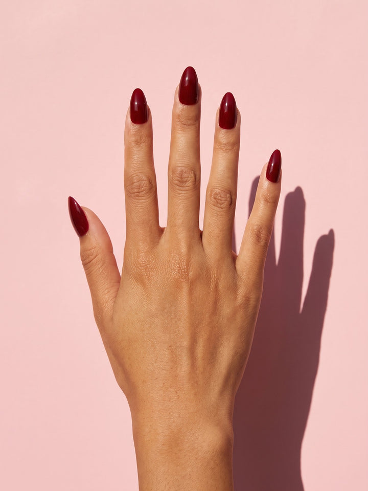 Wine Red Almond Press-On Nails on a hand
