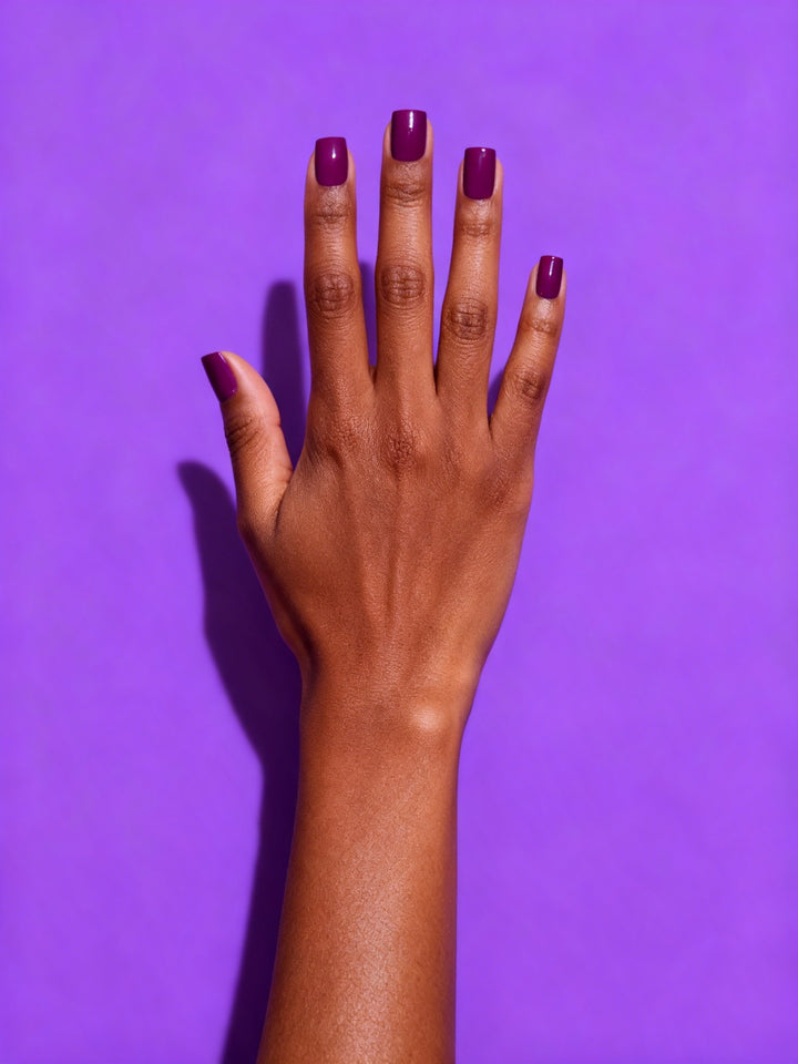 Plum press-on nails on a hand