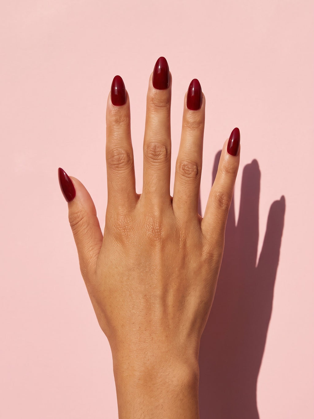 Wine Red Almond Press-On Nails on a hand