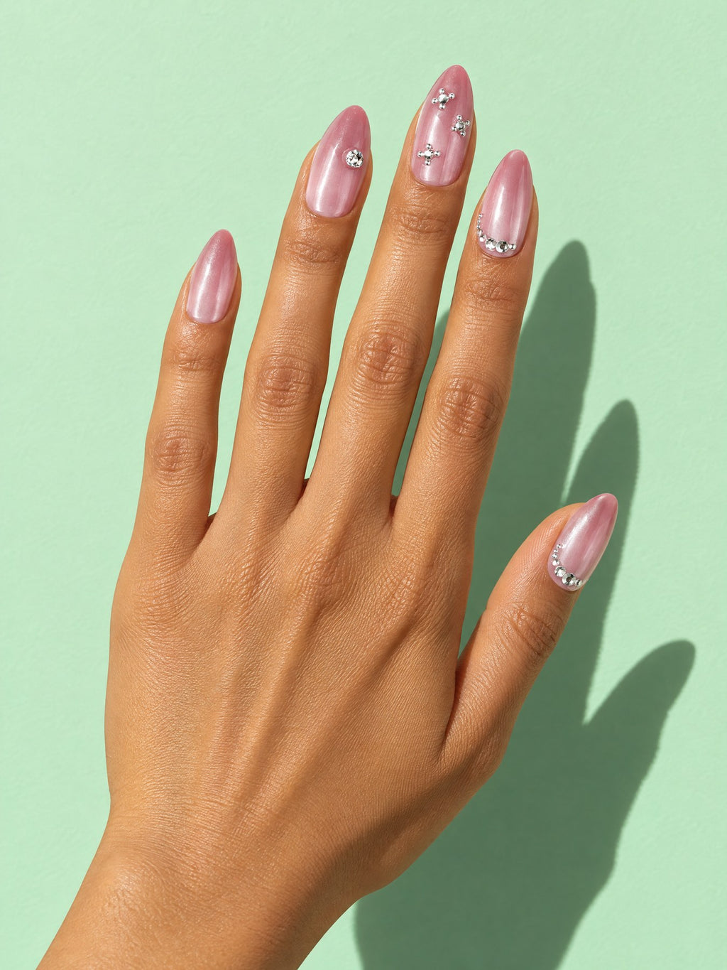 Pink Cat Eye Rhinestone Almond Press-On Nails on a hand