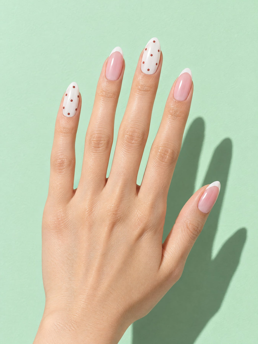 Polka Dot Blush French Almond Press-On Nails on a hand