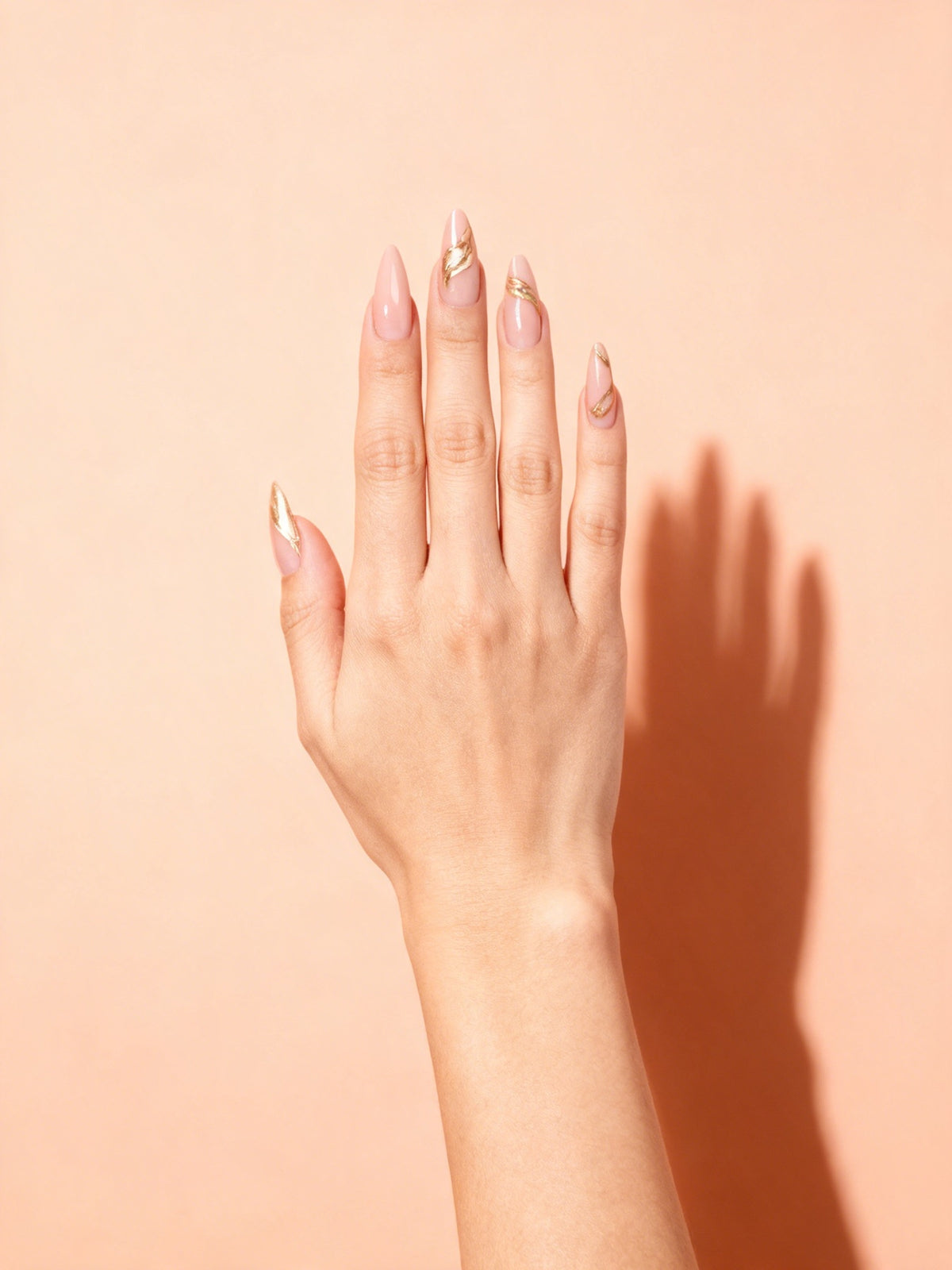 Gold Swirl Chrome Stiletto Press-On Nails on a hand