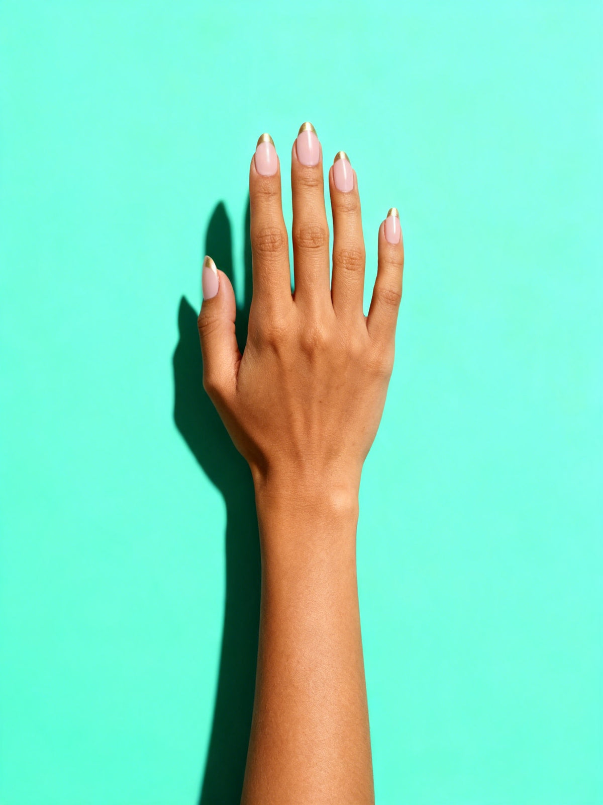Gold-Tip French Almond Press-On Nails on a hand
