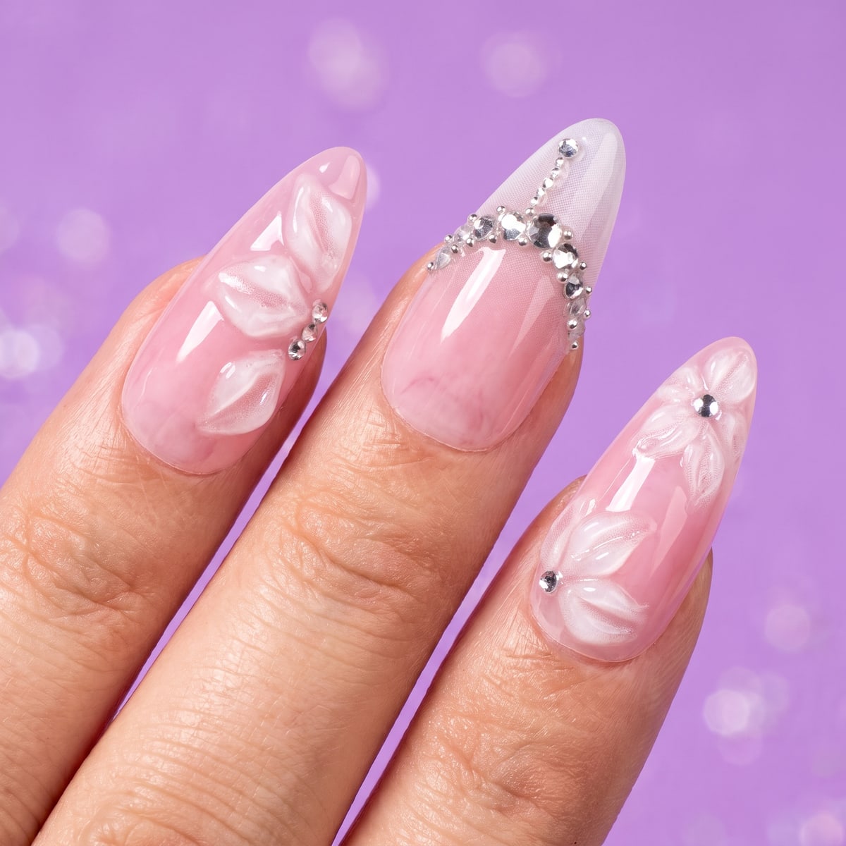 Macro texture tile: pink marble stiletto nails with sparkling rhinestones on lilac with soft glitter bokeh
