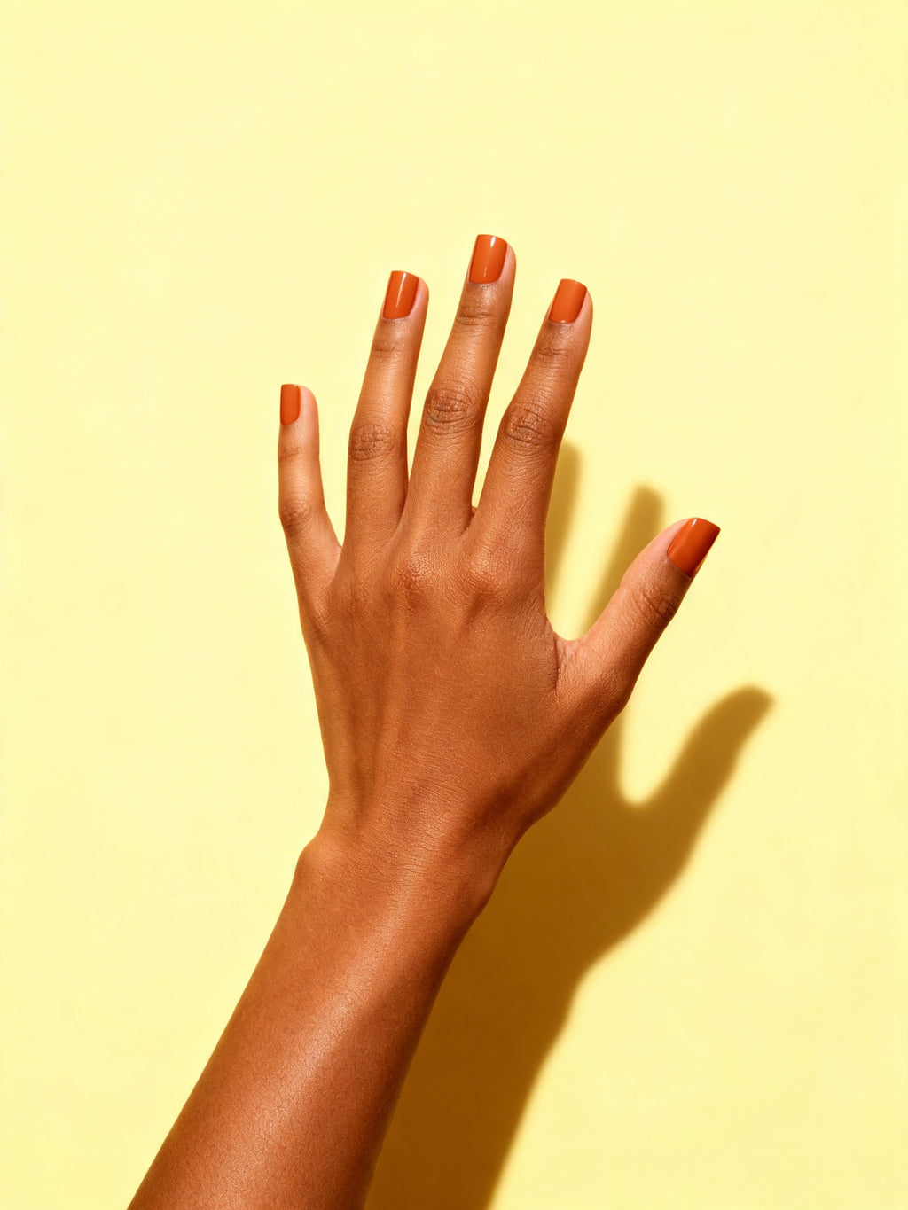 Burnt Orange press-on nails on a hand