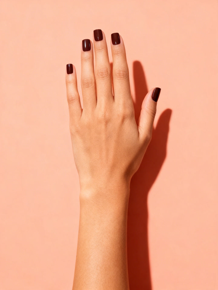 Oxblood press-on nails on a hand